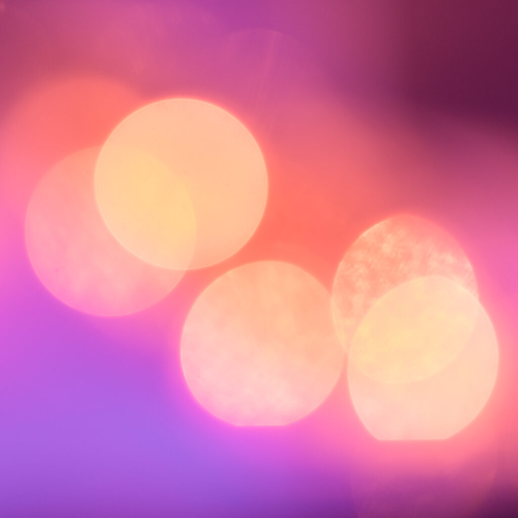 Photo flou de 5 point lumineux formant de grosses taches jaune, sur font violet/rouge