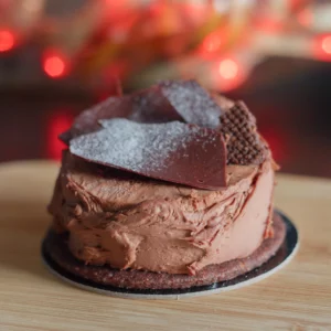 Photo d’un gâteau type buche au chocolat (végane) avec en fond des bokeh de lumière rouge de forme hexagonales