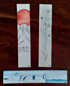 3 marque-pages : l'un du mont fuji avec écrit "lecture" en japonais, un motif floral sur fond coloré et des manchots sur la banquise.